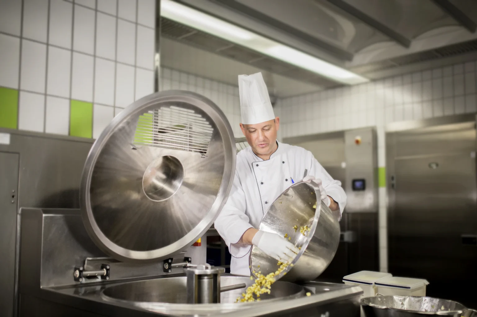 Foto: Koch an einem Kochkessel in der Großküche (© Ernährung-NRW e. V.)