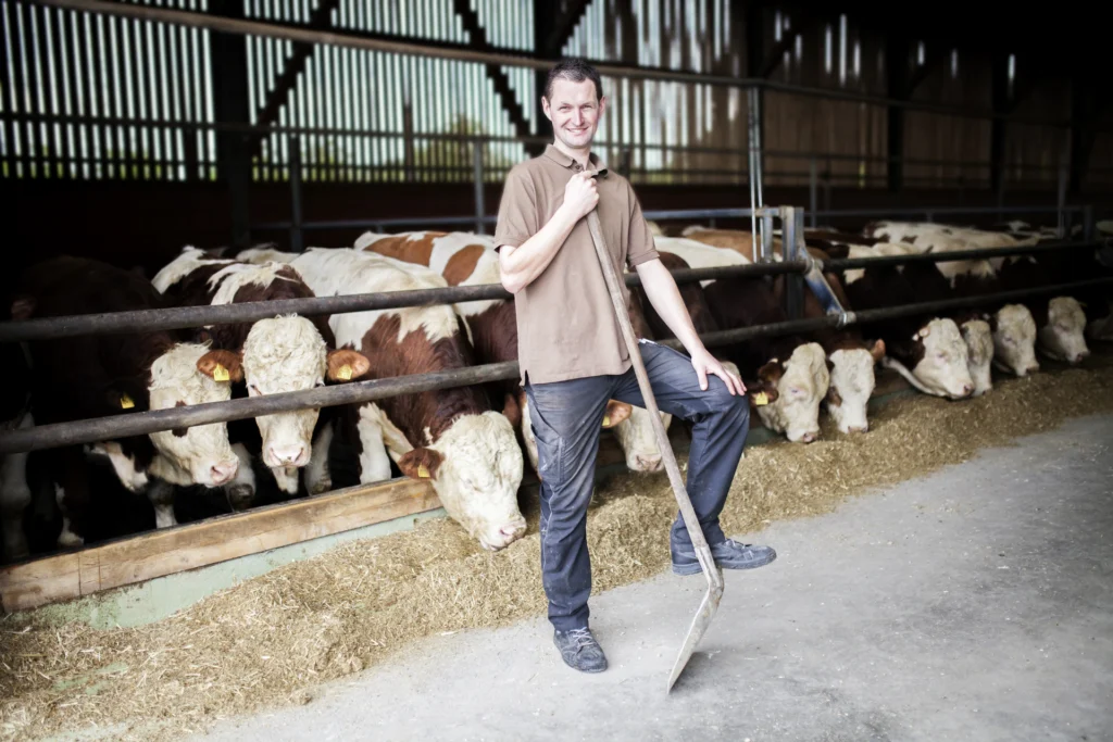 Foto: Landwirt im Rinderstall (© Ernährung-NRW e. V.)